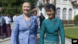 Burma's pro-democracy opposition leader Aung San Suu Kyi, right, and U.S. Secretary of State Hillary Rodham Clinton tour the grounds after meetings at Suu Kyi's residence in Rangoon, Burma December 2, 2011.