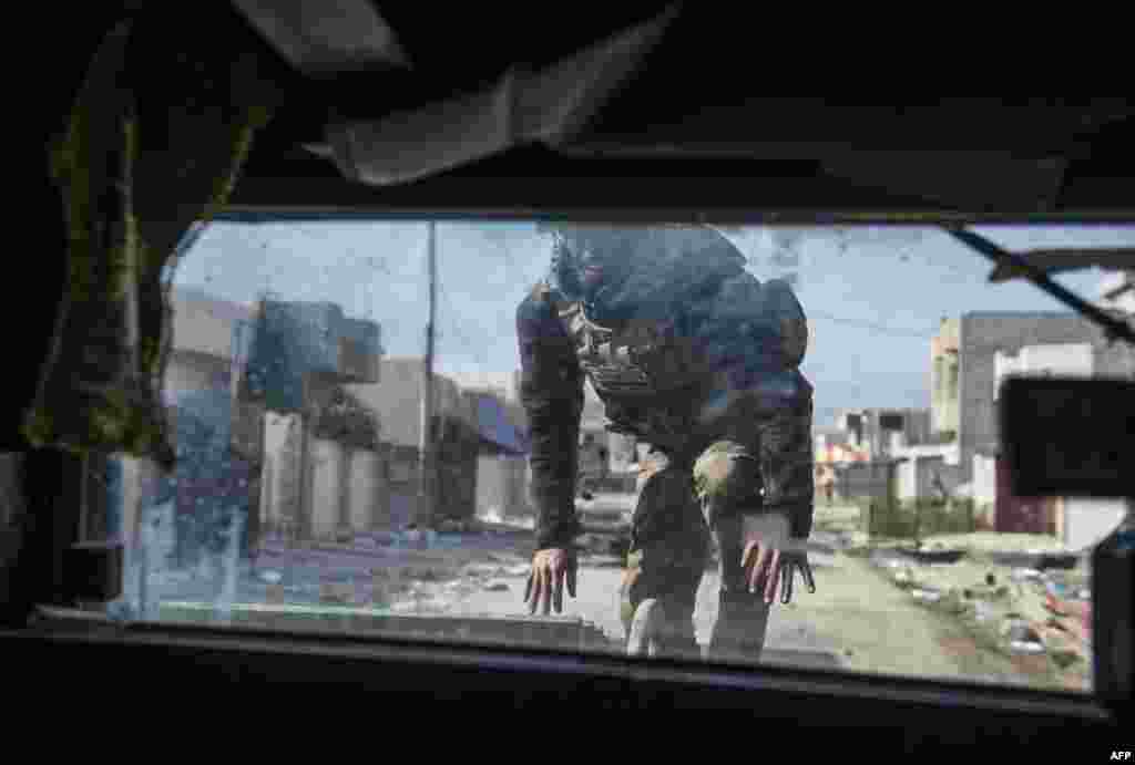 A gunner from the Iraqi Special Forces 2nd division jumps onto his fighting vehicle to take his position as they forces engage Islamic State fighters pushing through the Samah area and into the Arbagiah neighbourhood of Mosul.