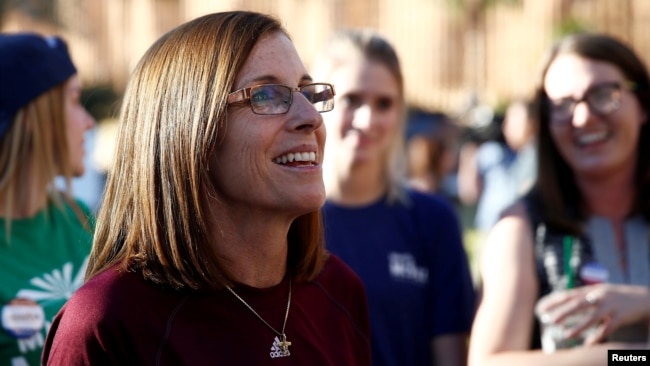 FILE - Republican U.S. Senate candidate Rep. Martha McSally, center, talks with people waiting in line at the ASU Palo Verde West polling station during the U.S. midterm elections in Tempe, Arizona, Nov. 6, 2018.