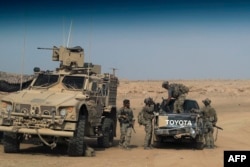 FILE - U.S.-backed forces are pictured near the village of Susah in the eastern province of Deir el-Zour, near the Syrian border with Iraq, Sept. 13, 2018.