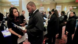 Daniela Silvero, left, an admissions officer at ASA College, discusses job opportunities with Patrick Rosarie, who is seeking a job in IT, during JobEXPO's 2012 job fair in New York.