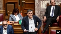 Greece's Finance Minister Euclid Tsakalotos (C) pauses during a parliamentary session in Athens, May 22, 2016. Greek lawmakers voted on a bill ahead of a Eurogroup meeting next week which is expected to unlock bailout funds for the country.