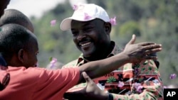 Pierre Nkurunziza, président actuel du Burundi et du CNDD-FDD Parti, salue un partisan lors de sa campagne électorale à Gatumba, 20 km à l'extérieur de la capitale du Burundi, Bujumbura, le Jeudi 24 Juin 2010.