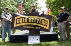 FILE - Stewart Rhodes, founder of the citizen militia group known as the Oath Keepers, center, speaks during a rally outside the White House in Washington, June 25, 2017.