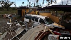 지난해 9월 허리케인 마리아가 미국령 푸에르토리코를 덮친 후 차가 건물의 잔해에 묻혀있다. 