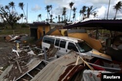 지난해 9월 허리케인 마리아가 미국령 푸에르토리코를 덮친 후 차가 건물의 잔해에 묻혀있다.