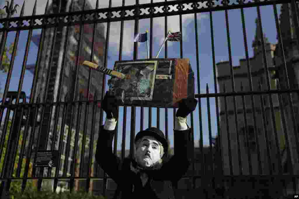 A silent performer holds up a Brexit-related placard outside the Houses of Parliament in London.