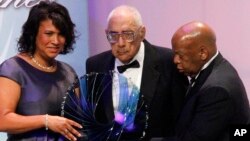 FILE - Journalist Simeon Booker, center, is presented with a Phoenix Award at the Congressional Black Caucus Foundation's annual Legislative Conference Phoenix Awards Dinner in Washington, Saturday, Sept. 18, 2010. 