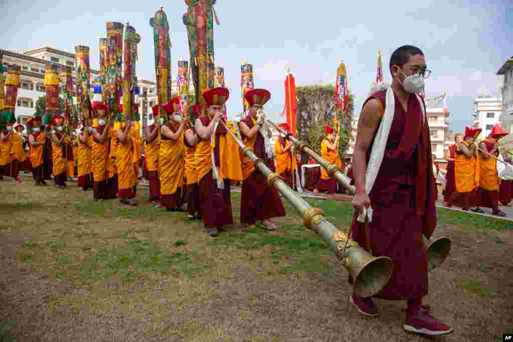 Nepalese Buddhist monks play traditional instruments during a procession after the body of Tsikey Chokling Rinpoche arrived at the Ka-Nying Shedrub Ling monastery in Kathmandu.
