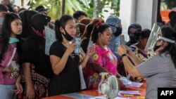 Warga menerima bantuan tunai langsung (BLT) sebesar Rp 600 ribu di tengah wabah virus corona, di Medan, Sumatra Utara, 18 Mei 2020. (Foto: AFP)