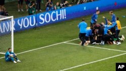 Les joueurs croates, à droite, jubilent après le tirs au but de la victoire, laissant le gardien de but russe Igor Akinfeev, à gauche, sans mots, lors du match de quart de finale opposant la Russie et la Croatie à la Coupe du monde 2018 au stade Fisht de 