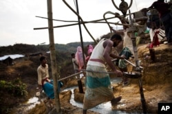 FILE - Bangladeshi laborers build a tube well in a Rohingya refugee camp, in Cox's Bazar, Bangladesh, Oct. 29 2017.