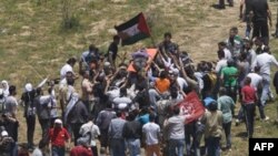 Người biểu tình khiêng xác một nạn nhân bị quân đội Israel bắn chết dọc biên giới giữa Israel và Syria gần làng Majdal Shams tại Cao Nguyên Golan
