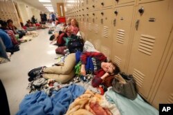 Emily Hindle lies on the floor at an evacuation shelter set up at Rutherford High School, in advance of Hurricane Michael, in Panama City Beach, Fla., Oct. 10, 2018.