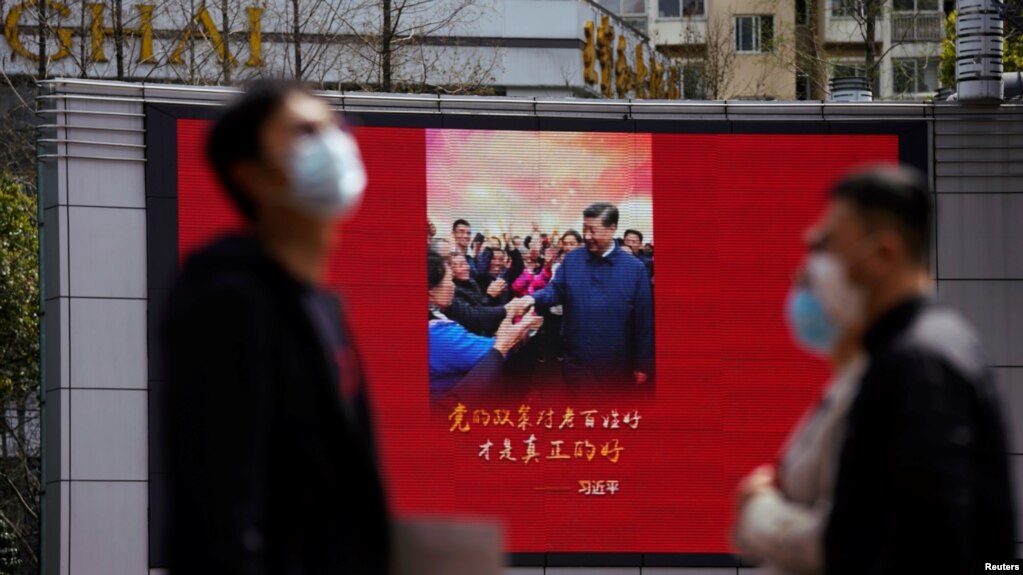 戴着口罩的行人走过上海街头宣传习近平的宣传画。（2020年3月23日）(photo:VOA)