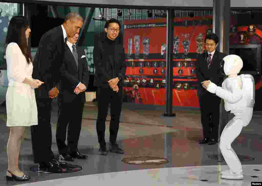 U.S. President Barack Obama (2nd L) bows to "Asimo" the robot while visiting Miraikan or the National Museum of Emerging Science and Innovation, in Tokyo, April 24, 2014. Obama assured ally Japan on Thursday that Washington was committed to its defence, i