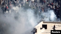 An armed man runs on a rooftop during clashes between police and protesters in Suez, Egypt, Jan. 28, 2011. 