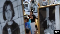 Cambodians hold portraits of Khmer Rouge victims during a protest in Phnom Penh in this June 9, 2013, file photo.
