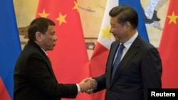 Presiden Filipina Rodrigo Duterte (kiri) berjabat tangan dengan Presiden China Xi Jinping di Beijing pada kunjungan 20 Oktober 2016 (foto: dok).