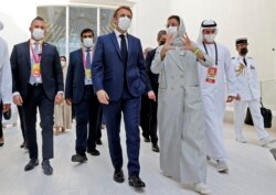 Presiden Prancis Emmanuel Macron (tengah) berbincang dengan Menteri Kebudayaan dan Pengembangan Pengetahuan UEA, Noura al-Kaabi (CR) selama turnya ke paviliun Prancis di Dubai Expo, 3 Desember 2021.