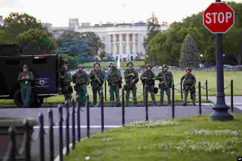 Law enforcement officers from Calvert County Maryland Sheriff&#39;s Office standing on the Ellipse, area just south of the White House in Washington, as they watch demonstrators protest the death of George Floyd, May 31, 2020.