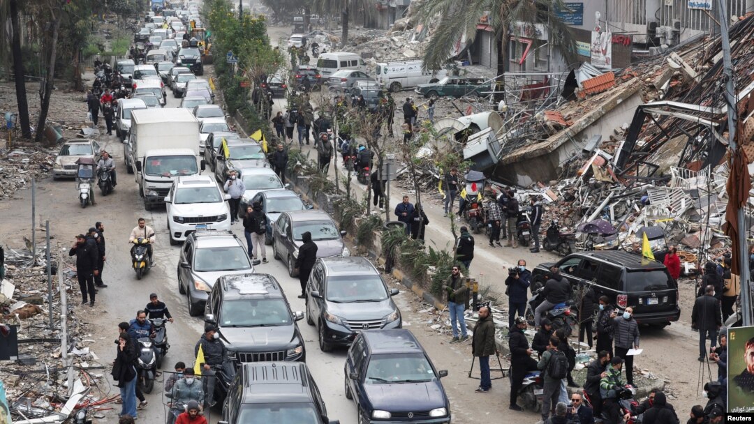 Los automóviles pasan junto a los escombros de los edificios dañados en los suburbios del sur de Beirut, luego de que un alto el fuego entre Israel y el grupo Hezbolá, entró en vigencia el miércoles, 27 de noviembre de 2024, en el Líbano. REUTERS/Mohamed Azakir