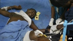 FILE - Nurses tend to a man lying in traction at a hospital in the Liberian capital of Monrovia.