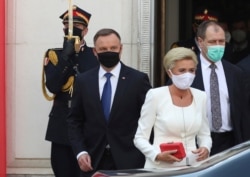 Poland's conservative President Andrzej Duda,left, and First Lady Agata Kornhauser-Duda, right leave the parliament building following the ceremony of Duda's swearing in for a second five-year term in Warsaw, Poland, August 6, 2020.