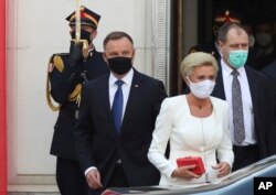 Poland's conservative President Andrzej Duda,left, and First Lady Agata Kornhauser-Duda, right leave the parliament building following the ceremony of Duda's swearing in for a second five-year term in Warsaw, Poland, August 6, 2020.