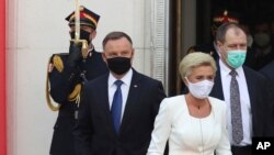 Poland's conservative President Andrzej Duda,left, and First Lady Agata Kornhauser-Duda, right leave the parliament building following the ceremony of Duda's swearing in for a second five-year term in Warsaw, Poland, August 6, 2020.