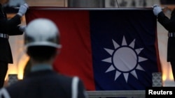 FILE - Honor guards lower a Taiwanese flag at Liberty Square, in Taipei, Taiwan, April 1, 2020.