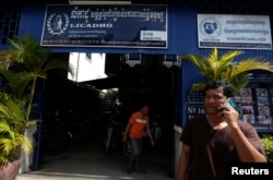 FILE - A man is on the phone in front of the office of the Cambodian League for the Promotion and Defense of Human Rights (Licadho), in Phnom Penh, Cambodia, Nov. 24, 2017.