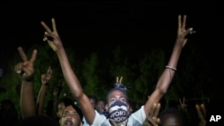 Sudanese protesters flash victory signs and shout slogans against the military council, as they gather during a sit-in, in Khartoum, Sudan, in Khartoum, June 20, 2019. 