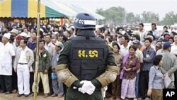 A Cambodian military policeman stands watch during the ground breaking ceremony of a Chinese funded road at Koun Damrey village, Banteay Meanchey province, about 15 kilometers (9 miles) east of Cambodia's border with Thailand, February 15, 2011.