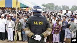 A Cambodian military policeman stands watch during the ground breaking ceremony of a Chinese funded road at Koun Damrey village, Banteay Meanchey province, about 15 kilometers (9 miles) east of Cambodia's border with Thailand, February 15, 2011.
