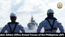 FILE - Philippine Navy personnel watch the Canadian vessel HMCS Montreal during the Multilateral Maritime Cooperative Activity being held in the West Philippine Sea, Aug. 7, 2024. 