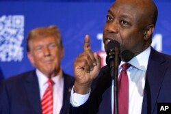 FILE - Sen. Tim Scott, R-S.C., speaks as Republican presidential candidate former President Donald Trump listens at a campaign event in Concord, N.H., January 19, 2024.