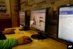 FILE - An Indian man checks a Facebook page at an internet cafe in New Delhi, Feb. 9, 2016.