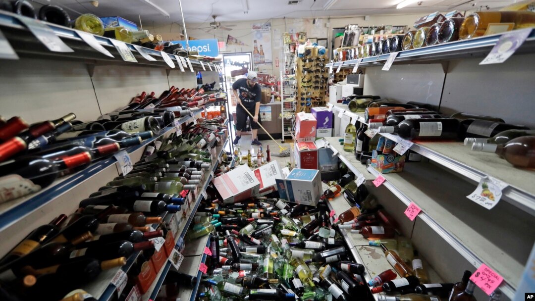 Botol-botol anggur berserakan di tengah lorong saat Victor Abdullatif (pemilik toko) membersihkan Eastridge Market, toko keluarganya di Ridgecrest, California, , Sabtu, 6 Juli 2019. 