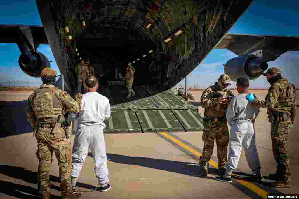 The first U.S. military aircraft to carry detained migrants whom U.S. Department of Homeland Security spokesperson Tricia McLaughlin called &quot;highly dangerous criminal aliens&quot;, to a detention facility at Guantanamo Bay, is boarded from an unspecified location in the U.S., Feb. 4, 2025&nbsp;