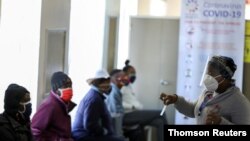 FILE PHOTO: A medical worker talks to volunteers as they wait to receive an injection during the country's first human clinical trial for a potential vaccine against the novel coronavirus, in Soweto.