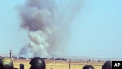 Turkish soldiers watch smoke billow from the Syrian town 