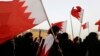 FILE - Opposition protesters, holding Bahraini flags, are seen during an anti-government rally in Sitra, south of Manama, June 28, 2013.