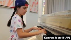 Michelle Rasul plays piano in the lobby of her apartment building in Dubai, United Arab Emirates, Sunday, May 9, 2021. (Foto: AP/Kamran Jebreili)