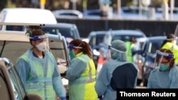Medical workers administer tests at the Bondi Beach drive-thru coronavirus disease (COVID-19) testing center in the wake of new positive cases in Sydney, Australia, June 17, 2021. 