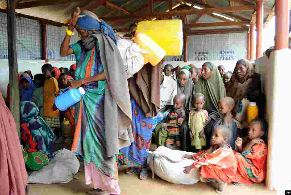 索马里妇女儿童在达加哈雷难民营内等待领取救援物资。