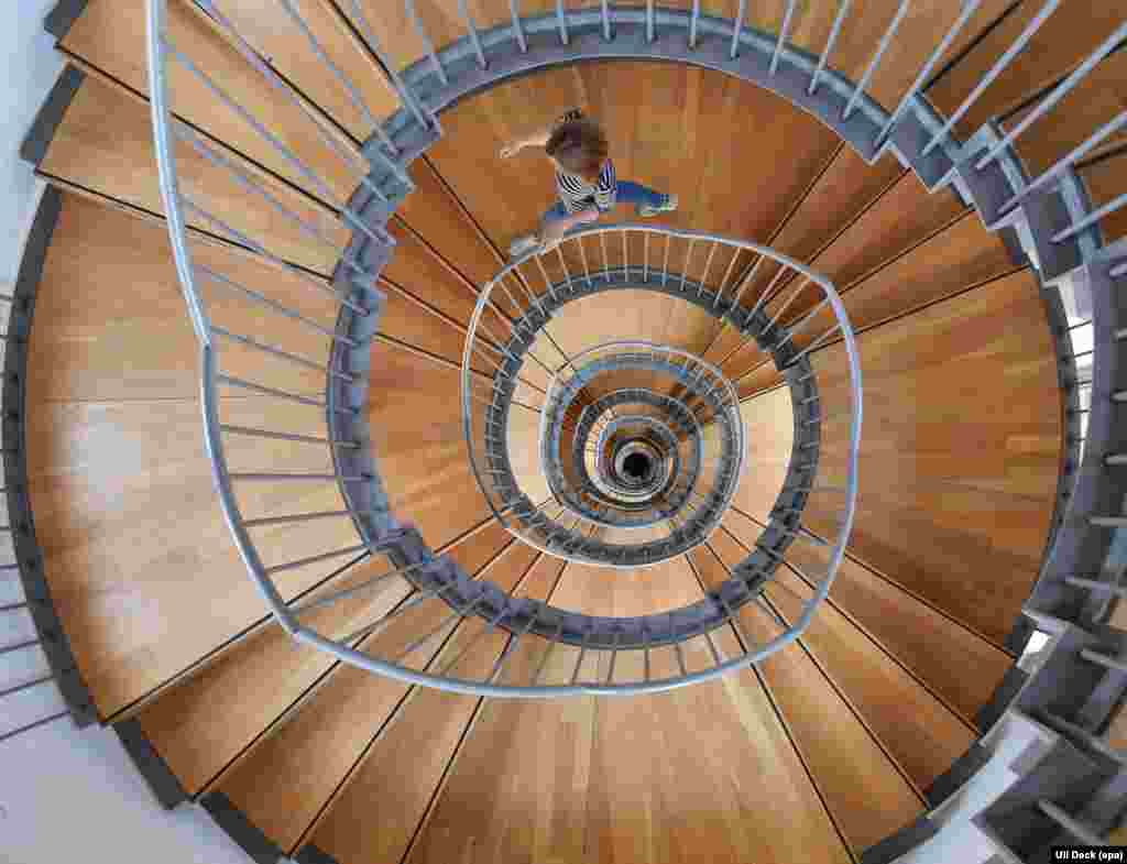 A woman walks down a spiral staircase at Gottesaue castle in Karlsruhe, Germany.