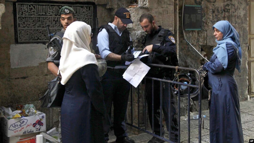 Polisi Israel memeriksa dokumen dua perempuan Palestina yang akan memasuki komplek kota tua Yerusalem, Kamis (8/10). 