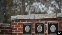 FILE - The faces of the three Finneytown students killed in a stampede at The Who's Dec. 3, 1979 concert, are displayed as part of a memorial at the Finneytown High School secondary campus in Finneytown, Ohio, Nov. 21, 2019. 