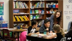 Chelsea Duvenez, upper right, works with students in her fourth-grade classroom at Olympic View Elementary School, Friday, March 9, 2018, in Lacey, Wash. (AP Photo/Ted S. Warren)